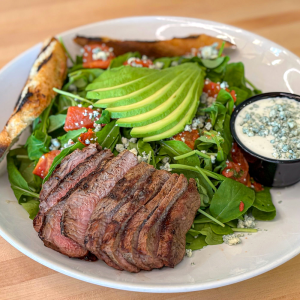 Grilled sirloin, arugula, avocado, oven-roasted tomato, blue cheese crumbles, blue cheese dressing and grilled bread. **contains wheat, dairy, egg, soy**