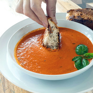 Creamy tomato soup cup served with Look s Bakehouse multigrain bread. **contains dairy**